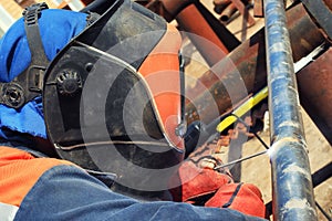 Welder in the mask and protective clothing is gaining increased cladding weld