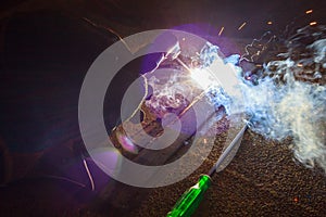 Welder perform welding to the metal plate at roof floor of manufacturing factory by using steel welding electrode in offshore oil