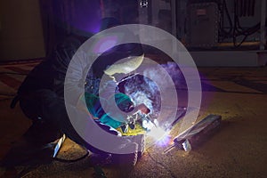 Welder perform welding to the metal plate at roof floor of manufacturing factory by using steel welding electrode in offshore oil