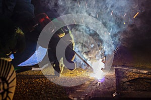 Welder perform welding to the metal plate at roof floor of manufacturing factory by using steel welding electrode in offshore oil