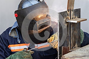 Welder qualification. The welder is welding with shielded metal arc welding process to steel plate in vertical position for welder