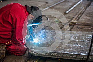 Welder in red suit with proper protection