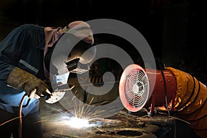 Welder repairing surface by shield metal arc welding photo