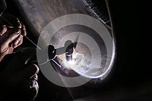 welder repairs aluminum car wheel