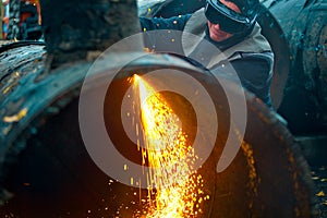 The welder sits near the pipe and cuts it with the help of cetylene welding.