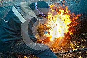 The welder sits near the pipe and cuts it with the help of cetylene welding.