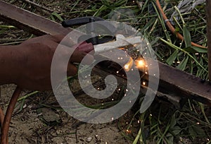 The welder using electrode welding the steel frame with welding machine, Welding sparks light and smoke