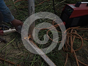 The welder using electrode welding the steel frame with welding machine, Welding sparks light and smoke