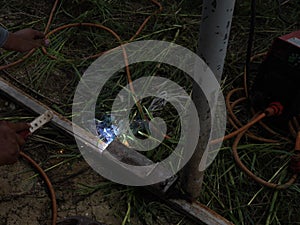 The welder using electrode welding the steel frame with welding machine, Welding sparks light and smoke