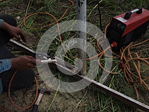 The welder using electrode welding the steel frame with welding machine, Welding sparks light and smoke