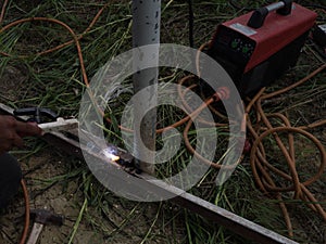 The welder using electrode welding the steel frame with welding machine, Welding sparks light and smoke