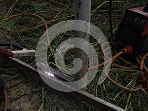 The welder using electrode welding the steel frame with welding machine, Welding sparks light and smoke