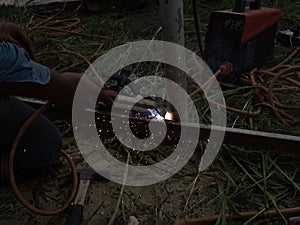 The welder using electrode welding the steel frame with welding machine, Welding sparks light and smoke