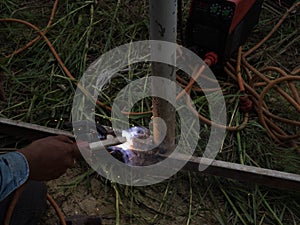 The welder using electrode welding the steel frame with welding machine, Welding sparks light and smoke