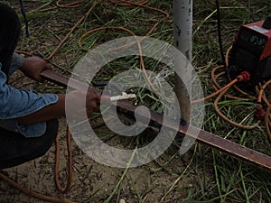 The welder using electrode welding the steel frame with welding machine, Welding sparks light and smoke