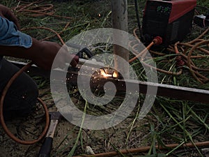 The welder using electrode welding the steel frame with welding machine, Welding sparks light and smoke