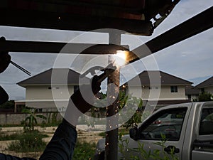 The welder using electrode welding the steel frame, Welding sparks light and smoke