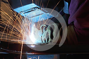 A welder using a wire feed welder to join two pieces of metal together. photo