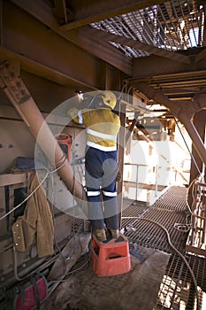 Welder wearing full safety equipment glove, mask using and standing up on industry safety steps while commencing welding parent me