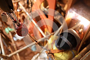 Welder wearing safety helmet fall arrest harness fall prevention device during welding