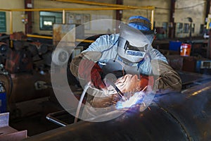 Welder is welding added joint a pipe carbon for steel structure work with process Flux Cored Arc Welding(FCAW)