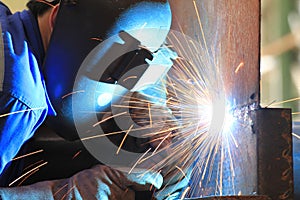 Welder is welding chekered plate with all safety