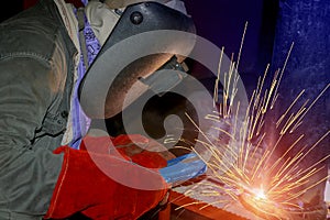 Welder is welding in factory