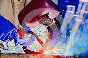 Welder is welding in factory