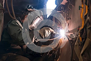 Welder in welding mask Dark tone style, repairing old fishing vessel