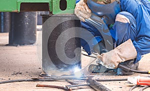 Welder is welding metal bollard for support foundation of the old steel container that have been renovated to outdoor office