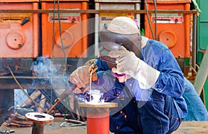 Welder is welding metal flange to connect with steel pipe for use improving oil pipeline systems work in tanker ship