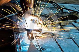 Welder is welding metal hook melting or fusing. Weldment of a steel door. Long exposure of welding fires flares