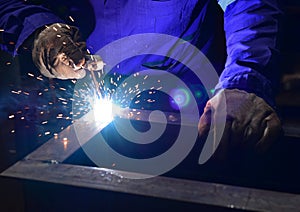 Welder is welding metal part