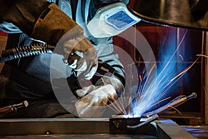 welder is welding metal part in car factory