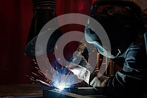 welder is welding metal part in car factory