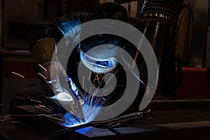 welder is welding metal part in car factory