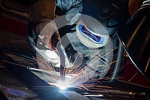 welder is welding metal part in car factory