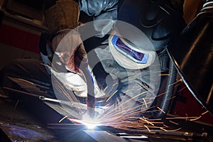 welder is welding metal part in car factory