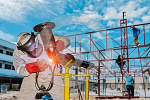 Welder is welding metal steel pipe in construction site