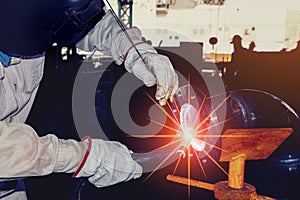 Welder is welding metal steel pipe in factory