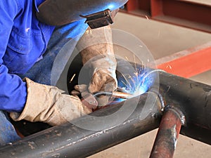 Welder is welding pipe structure with all safety photo