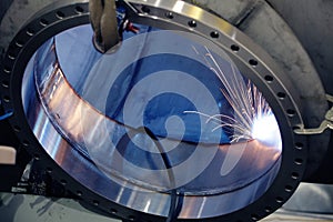 A welder welding a port onto a pressure vessel in a metal fabrication shop. photo