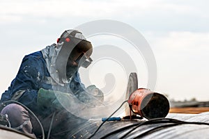 The welder is welding with shielded metal arc welding SMAW or manual metal arc welding process to eyebolt on the pipe in the con