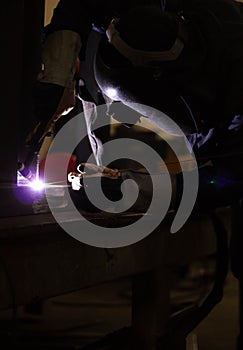 Welder is welding the steel in the factory