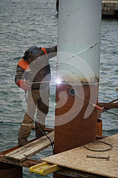 A welder is welding a steel pier pillar photo