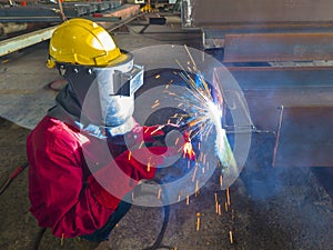 Welder welding a steel plate for steel structure work with process Flux Cored Arc Welding(FCAW)