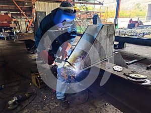 Welder Welding Steel Plate for Steel Structure Work with Process Flux Cored Arc Welding (FCAW)