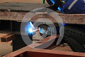 Welder is welding steel structure with all safety equipment
