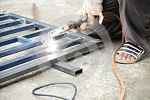 The welder is welding the steel structure to add to the house.