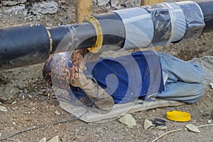 Welder welding underground steel pipe lying on ground 4